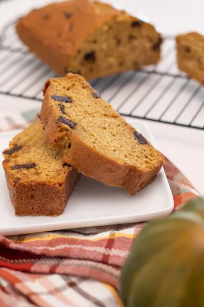 sliced chocolate chunk pumpkin bread vertical with gourd