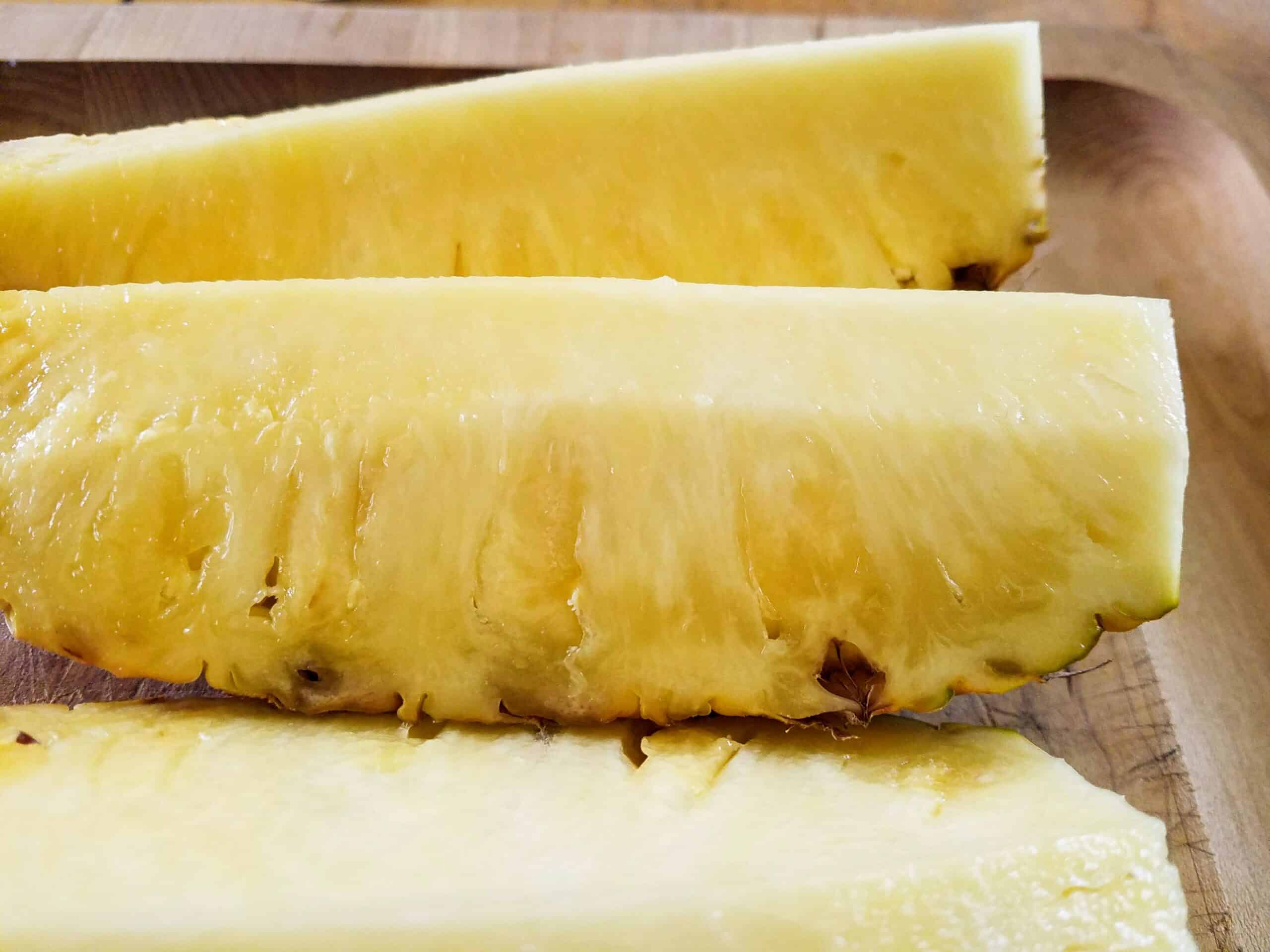 Pineapple ready to be peeled cut into spears