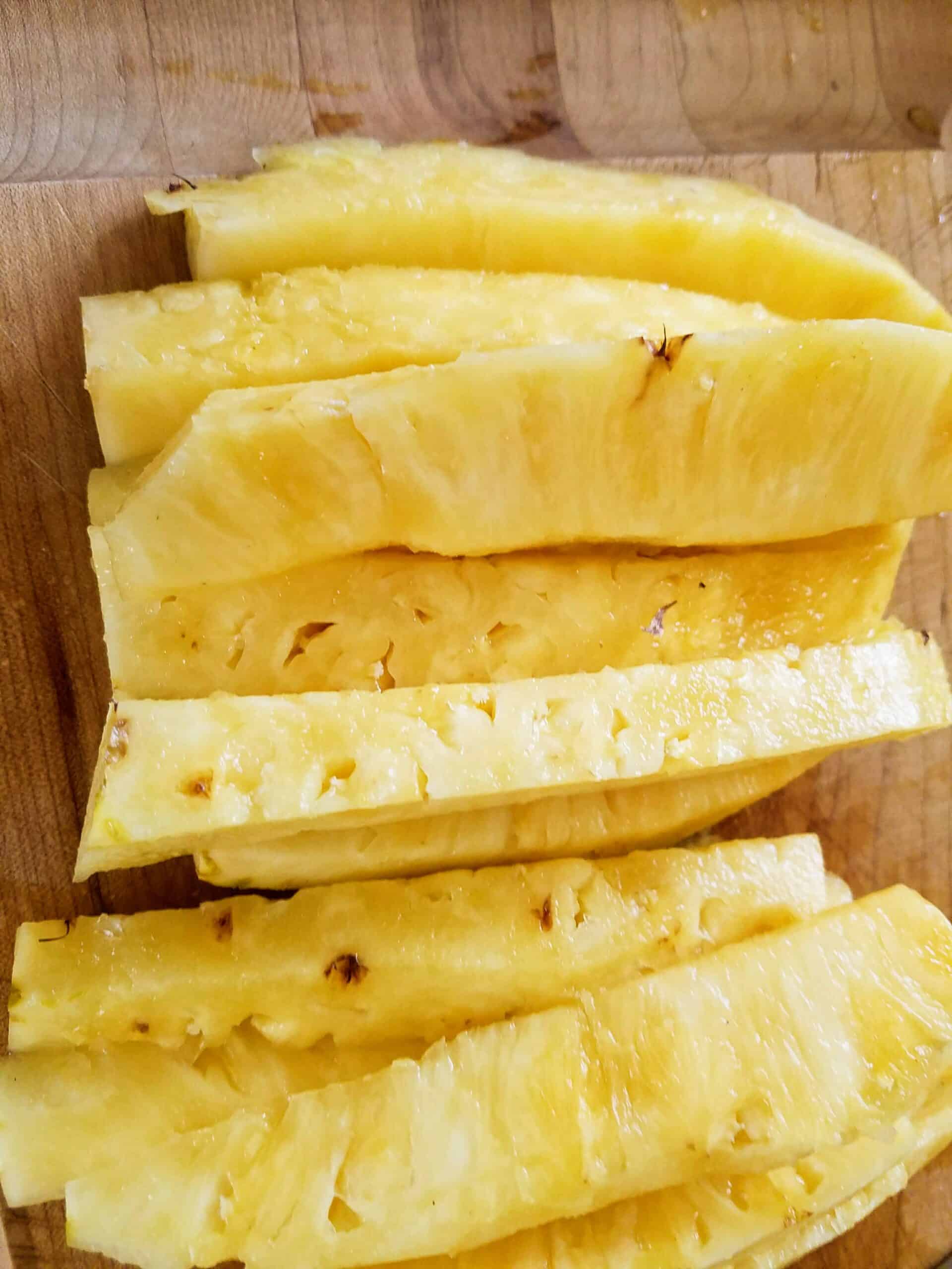 freshly cut pineapple slices on cutting board