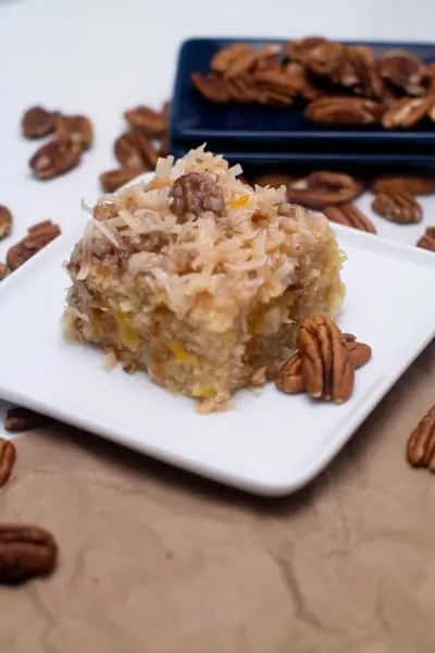coconut pecan pineapple cake on white plate serving