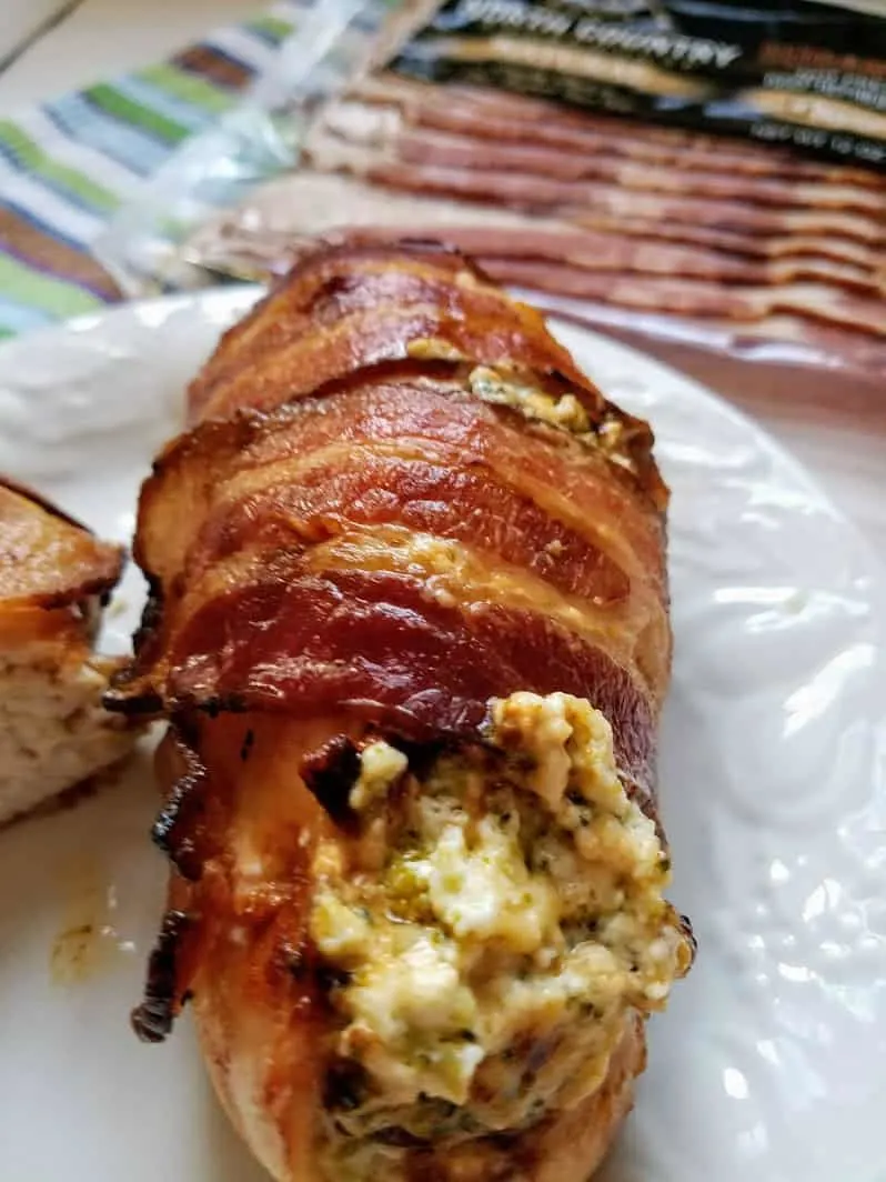 Keto Stuffed Bacon Wrapped Chicken close up with package of bacon in back ground