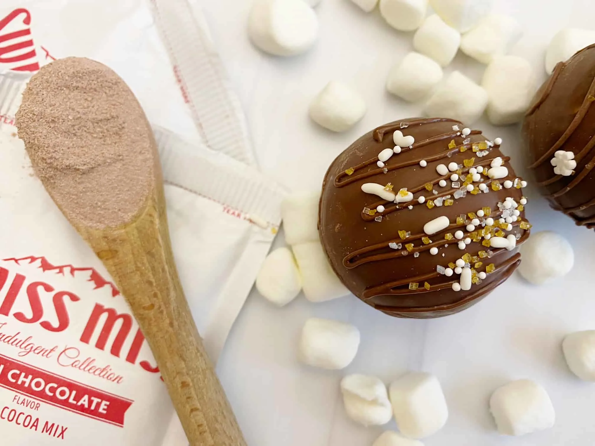 package swiss miss, wooden spoon, marshmallow, hot cocoa bomb