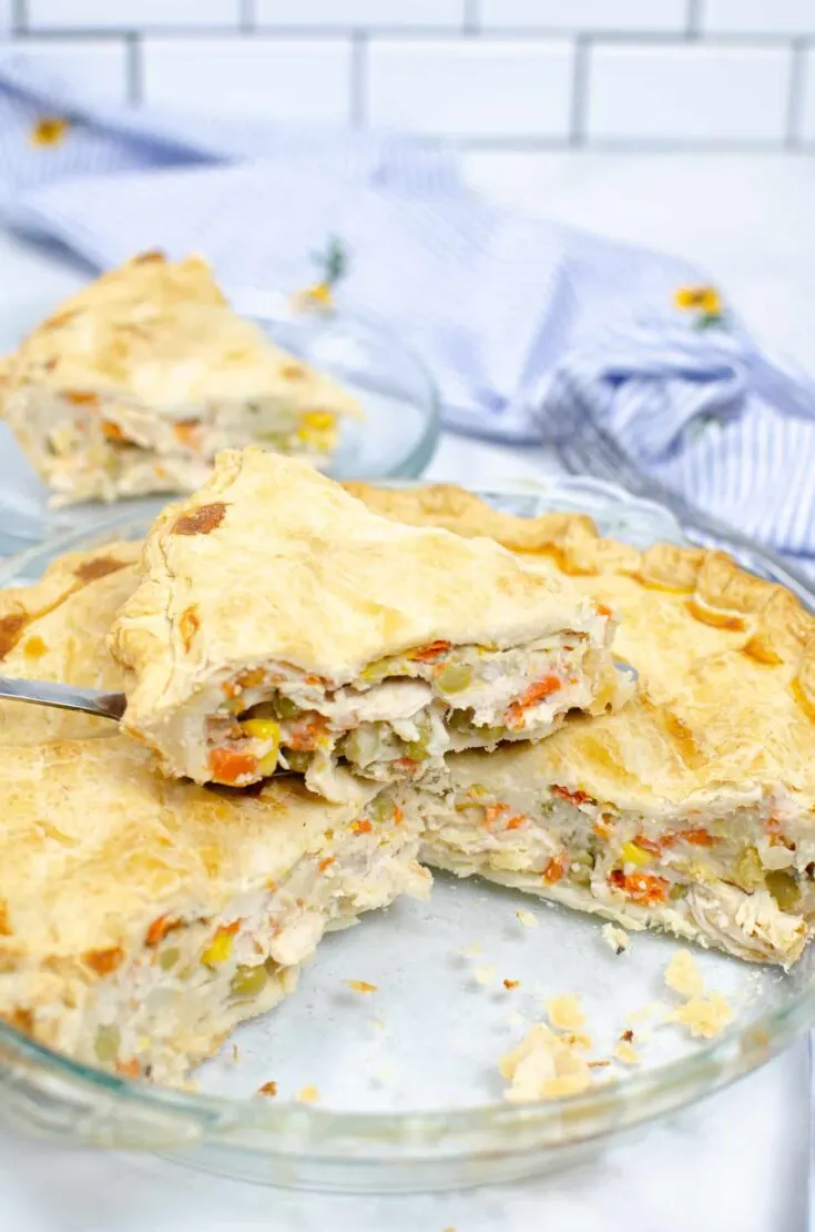 slice of turkey pot pie on top of whole pot pie