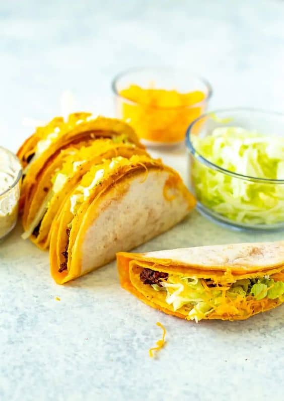 cheesy tacos with side of cheese and lettuce