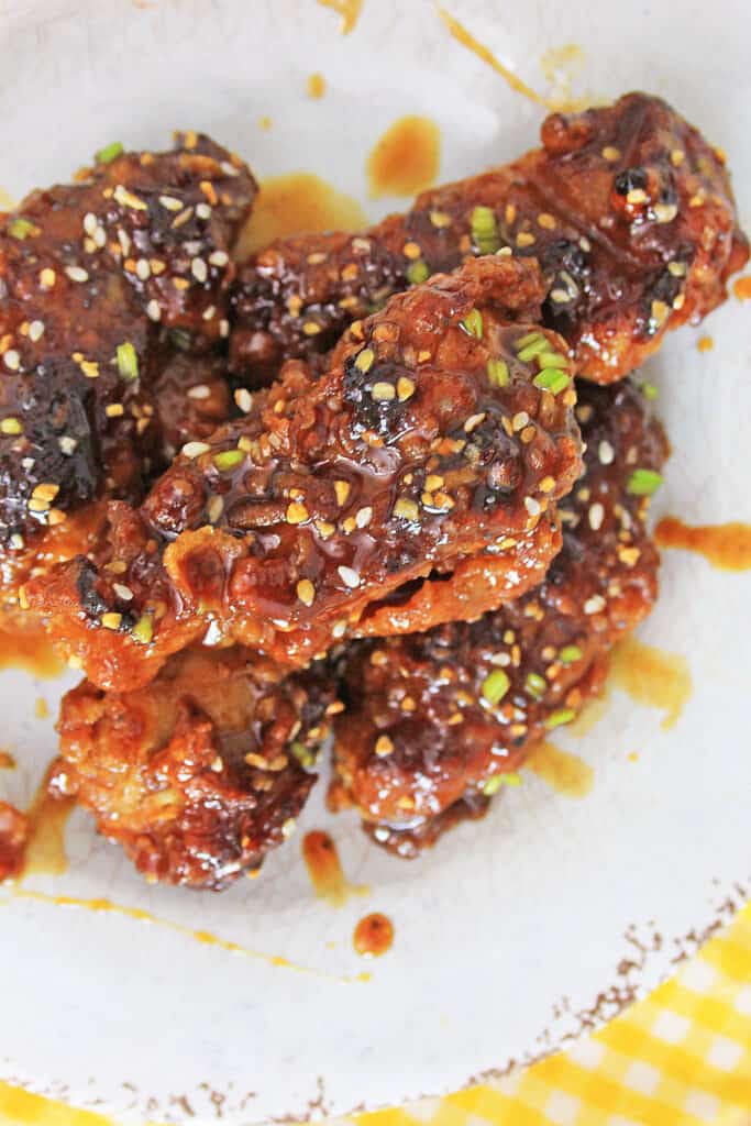 Air Fryer Korean BBQ Chicken Wings on a plate with drizzled sauce and scallions