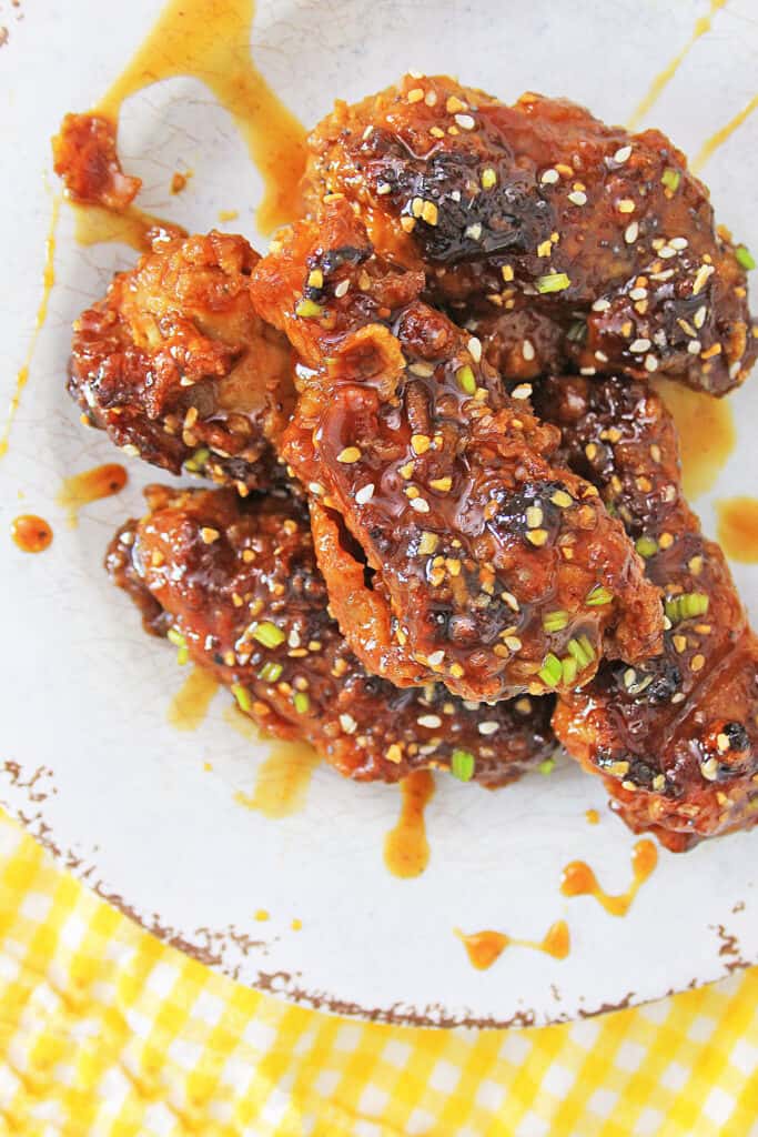 five Air Fryer Korean BBQ Chicken Wings on a plate with drizzled sauce
