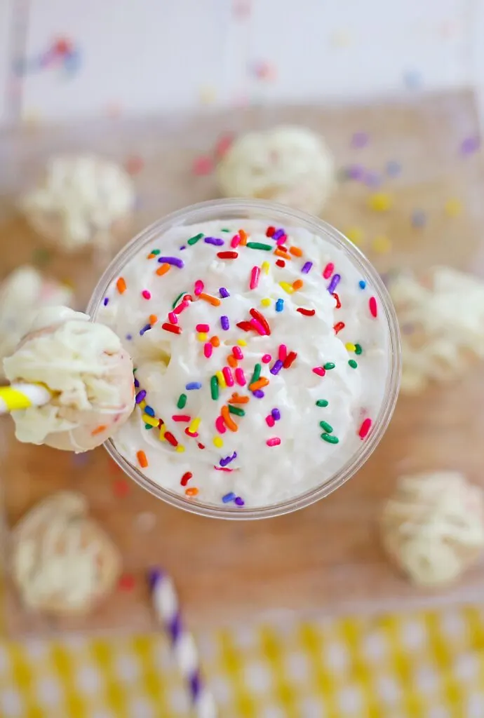 top shot of Copycat Starbucks Birthday Cake Frappuccino with extra sprinkles and a cake ball over the straw
