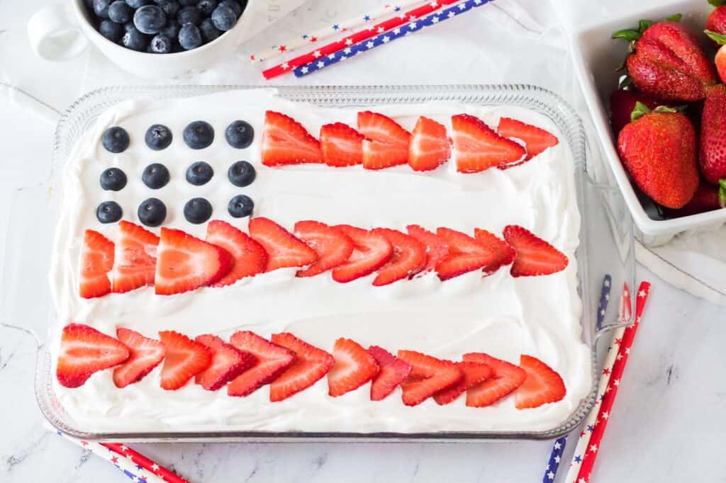 Hero Flag Poke Cake Recipe full cake not cut with berries and straws on the side