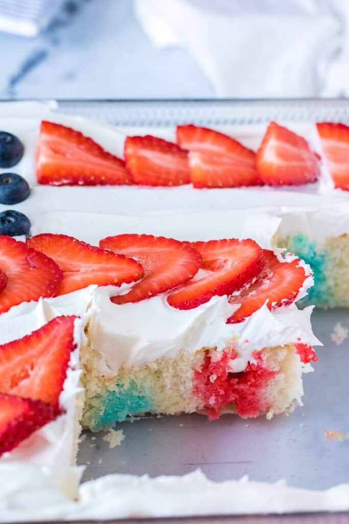 Decorated Flag Poke Cake with fresh strawberries and blueberries