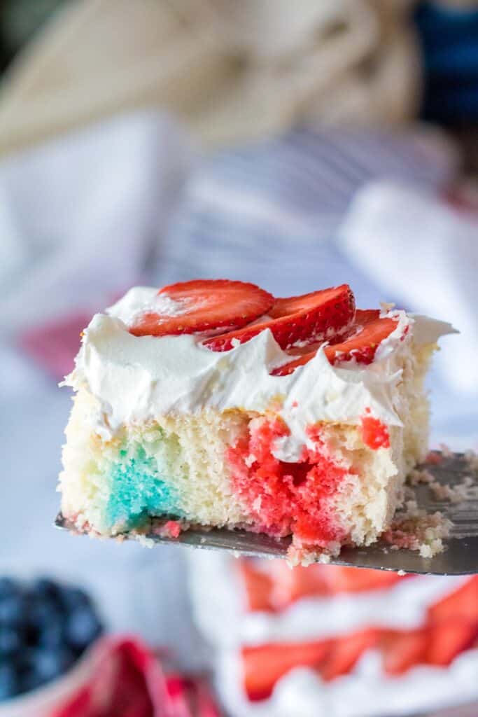 big slice of flag poke cake showing red white and blue throughout