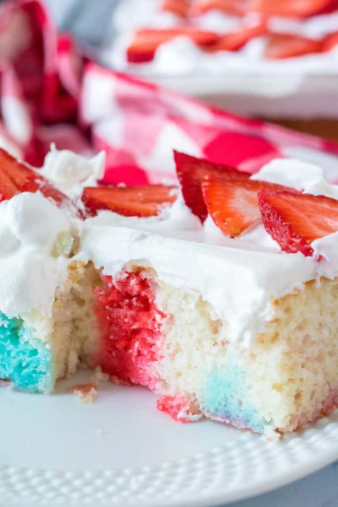 Flag poke cake is served with a moist red white and blue cake and topping