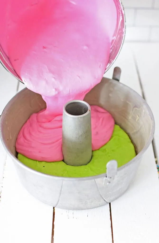 Pour the bright pink Cheesecake Batter into the tube Pan, on top of the green key lime Cake.