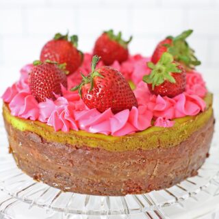 Key Lime Strawberry Cheesecake Cake full cake on cake serving plater topped with fresh strawberries
