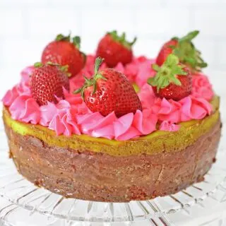 Key Lime Strawberry Cheesecake Cake full cake on cake serving plater topped with fresh strawberries