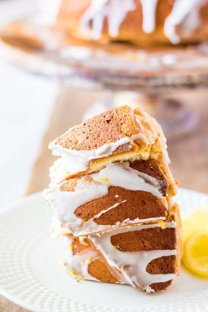 slice of cake Lemon Cream Cheese Bundt Cake with glaze lemon zest over wooden board cake, lemon slice