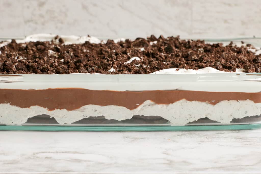 side view in a glass dish of 5 layer no bake oreo delight casserole dessert