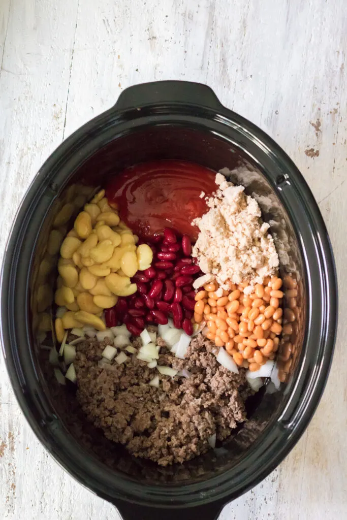 all of the beefy baked beans ingredients in the slow cooker