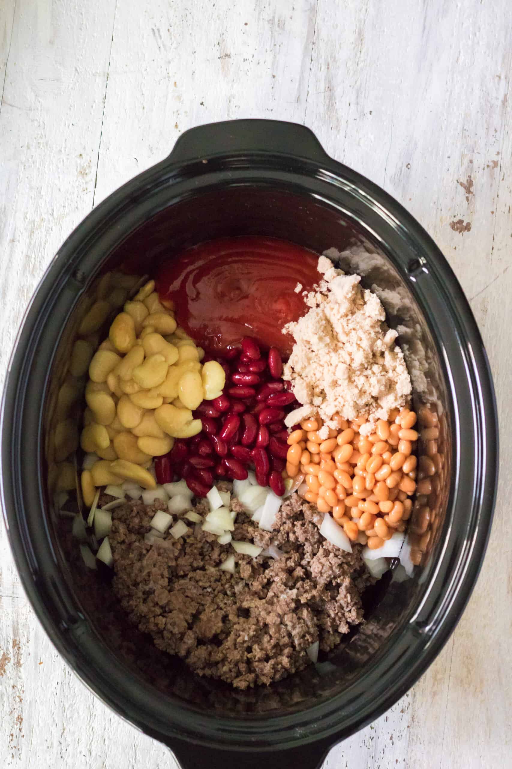 all of the ingredients for the slow cooker beefy baked beans in the slow cooker