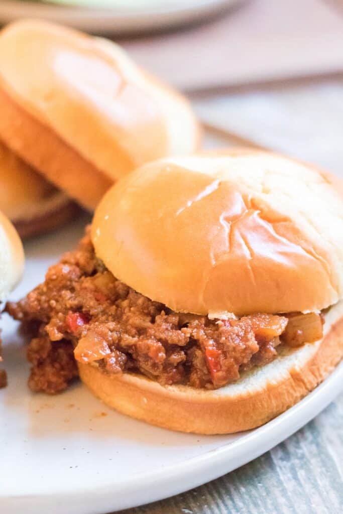 hero shot slow cooker sloppy joes served on a plate with potato chips, pickles