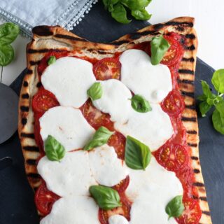 Grilled Margherita Pizza, toppings are redsauce, mozzarella, basil fresh