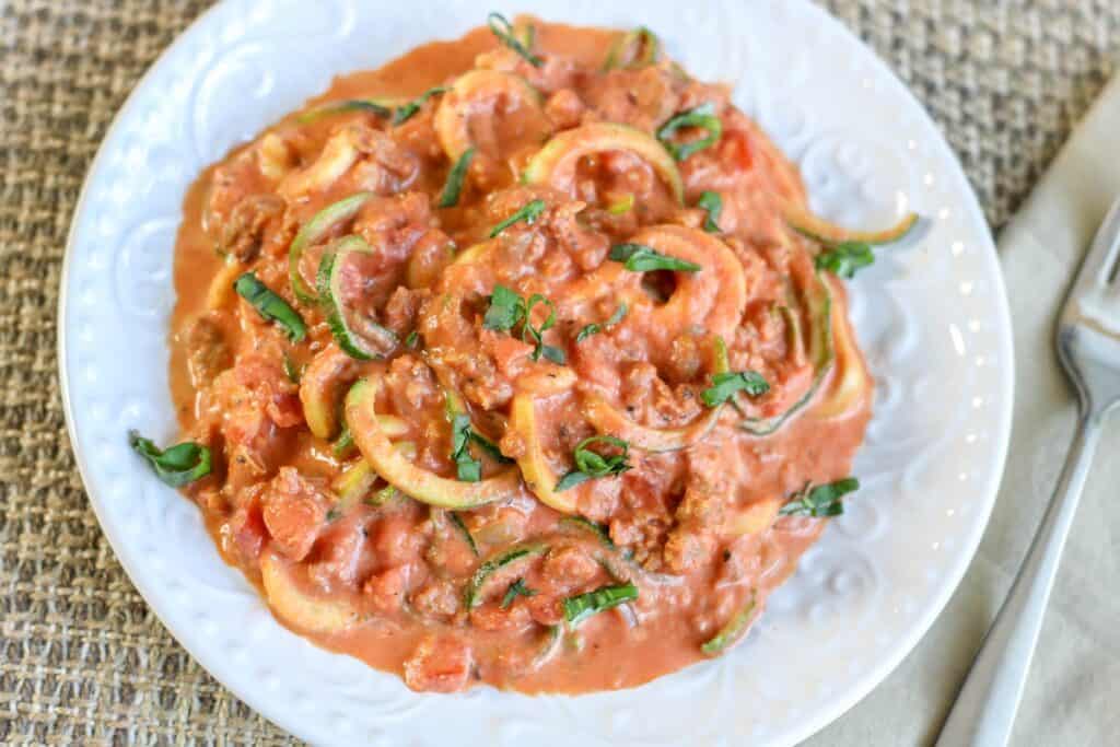 plated zoodles with sausage and creamy tomato sauce
