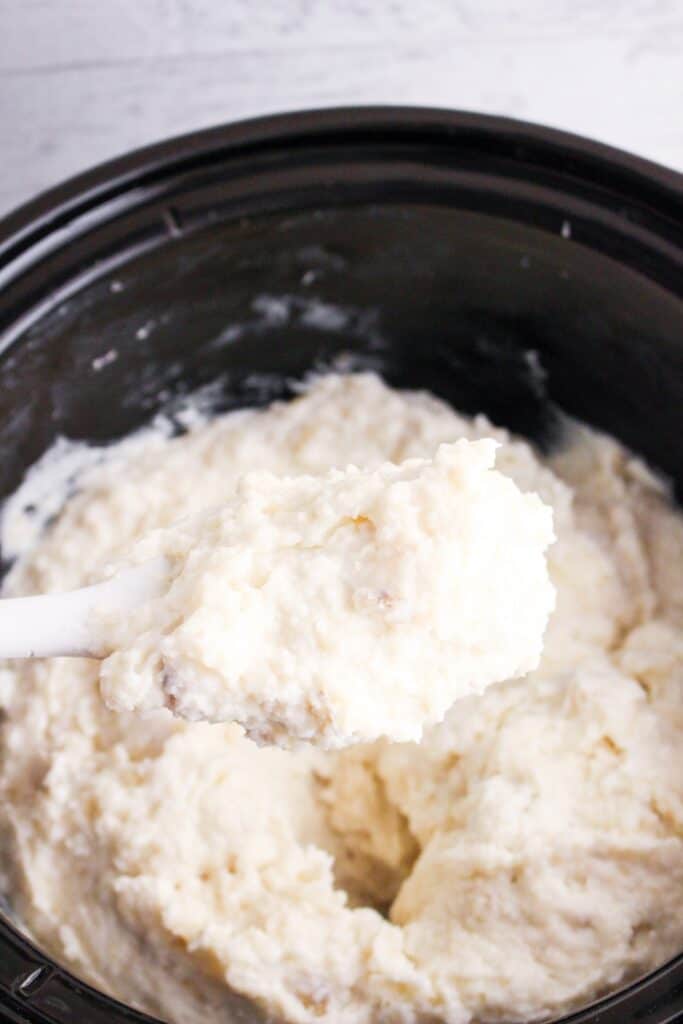 Ready to serve slow cooker mashed potatoes in a slow cooker with white ladle spoon