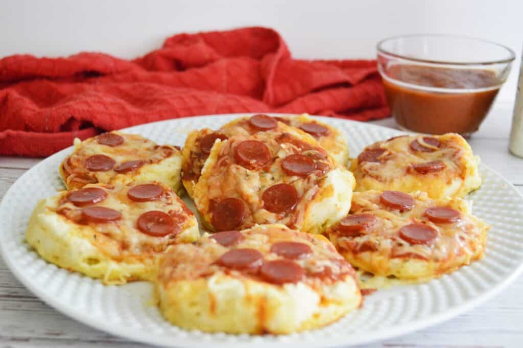 mini pepperoni pizzas on white serving plate marinara sauce red towel horizontal