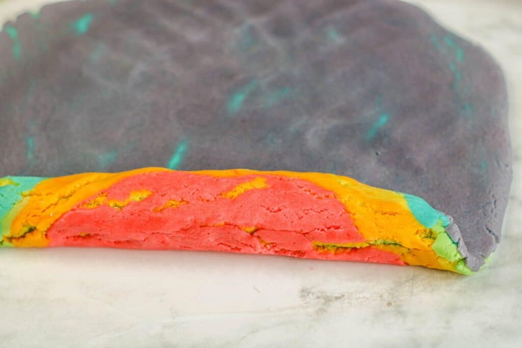 rolling up the layers of colored cookie dough