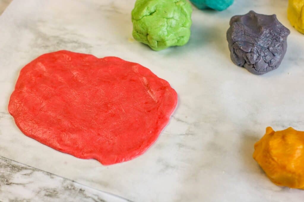 red cookie dough flattened out balls of colored dough