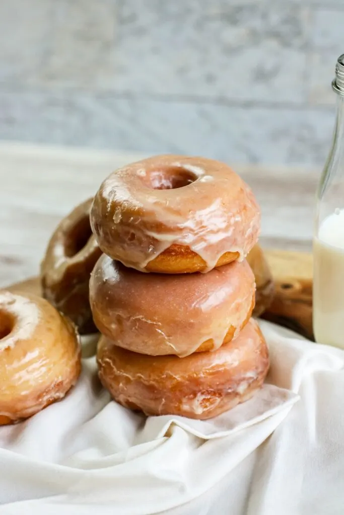 Homemade yeast doughnuts with a vanilla glaze hero stacked doughnuts with milk jug