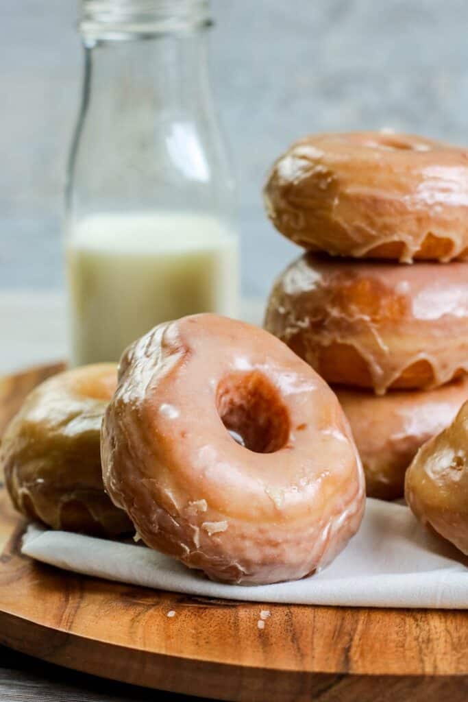 Homemade yeast doughnuts with a vanilla glaze hero stacked doughnuts with milk jug
