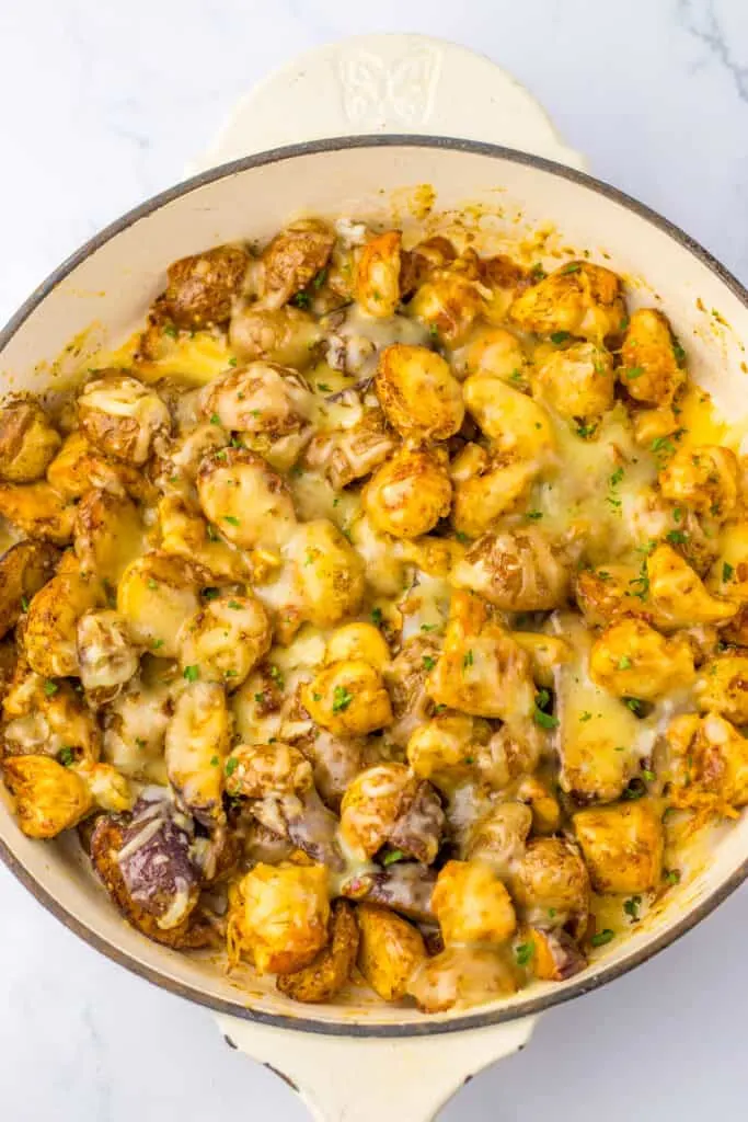 chicken and potatoes cooked in a white skillet