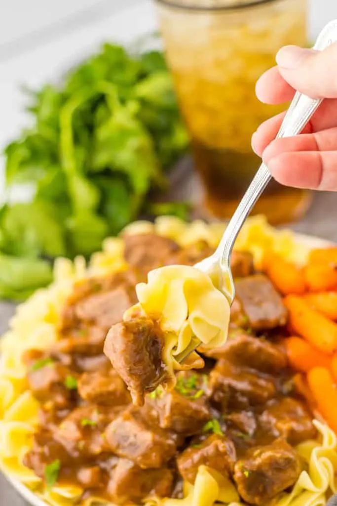 fork in slow cooker beef tips with noodles served with carrots