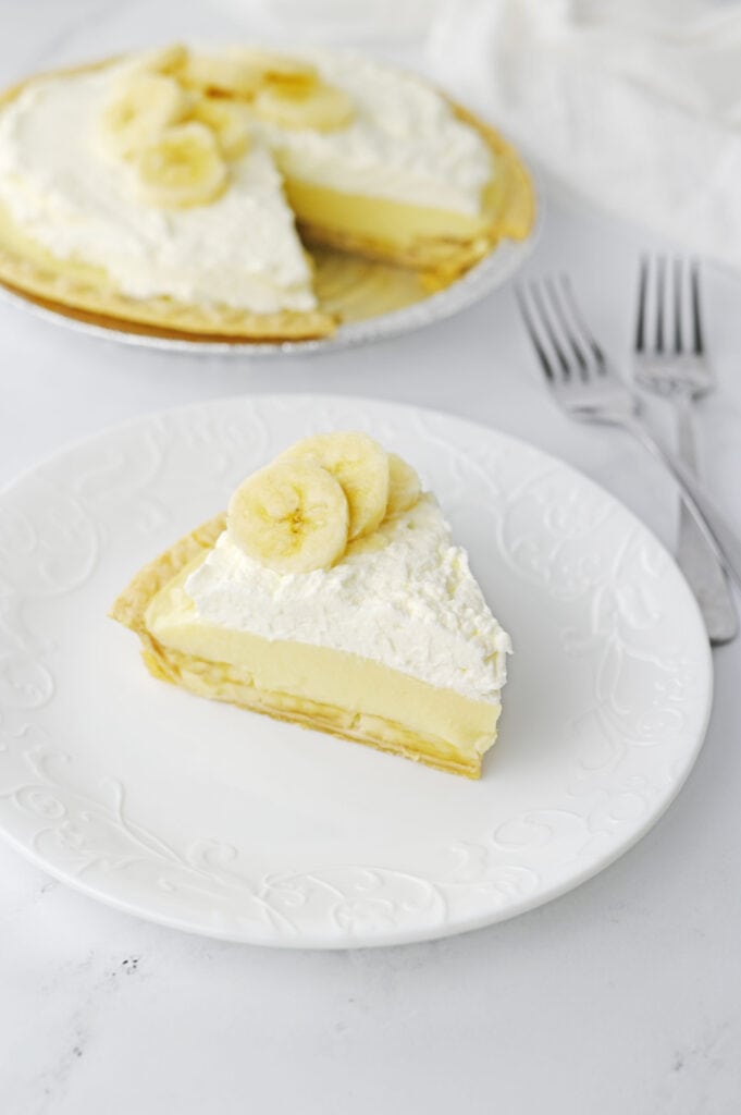 Banana Cream Pie slice up front whole pie back