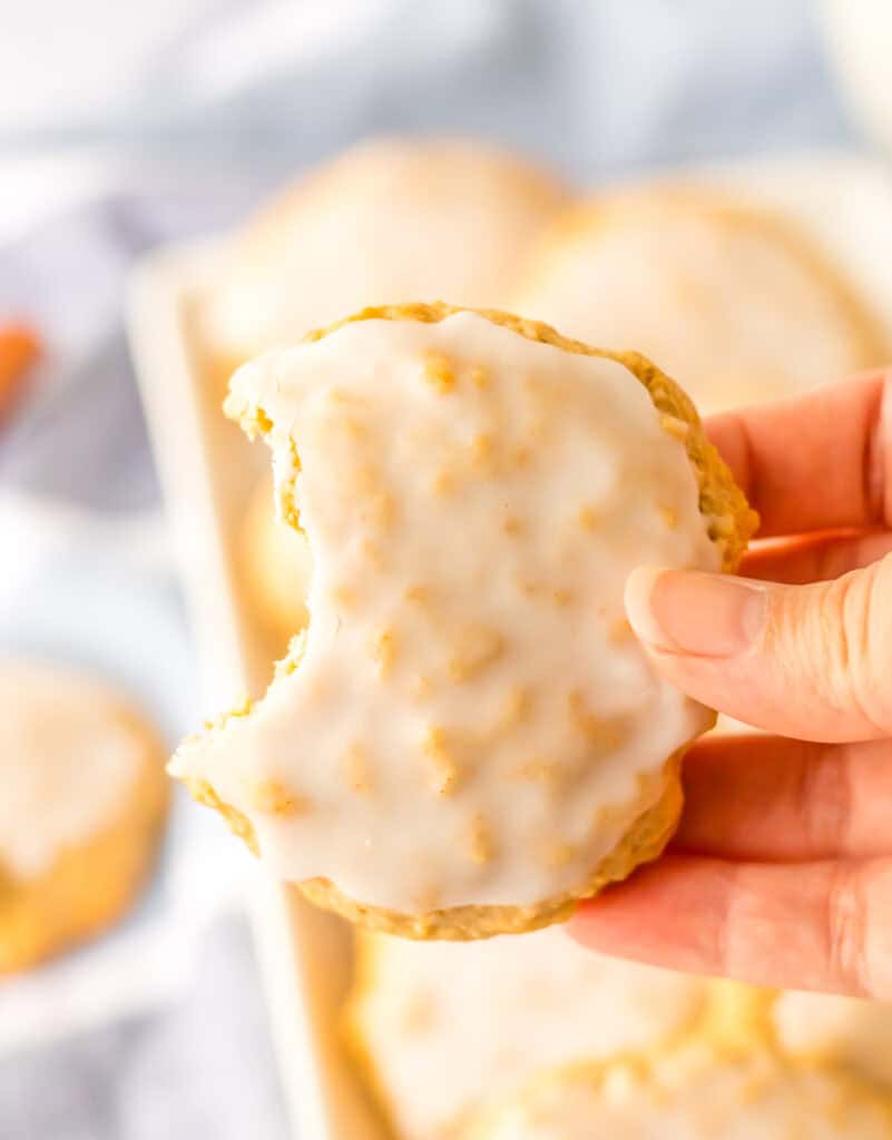 Old Fashioned Iced Oatmeal Cookies hand holding cookie bitten
