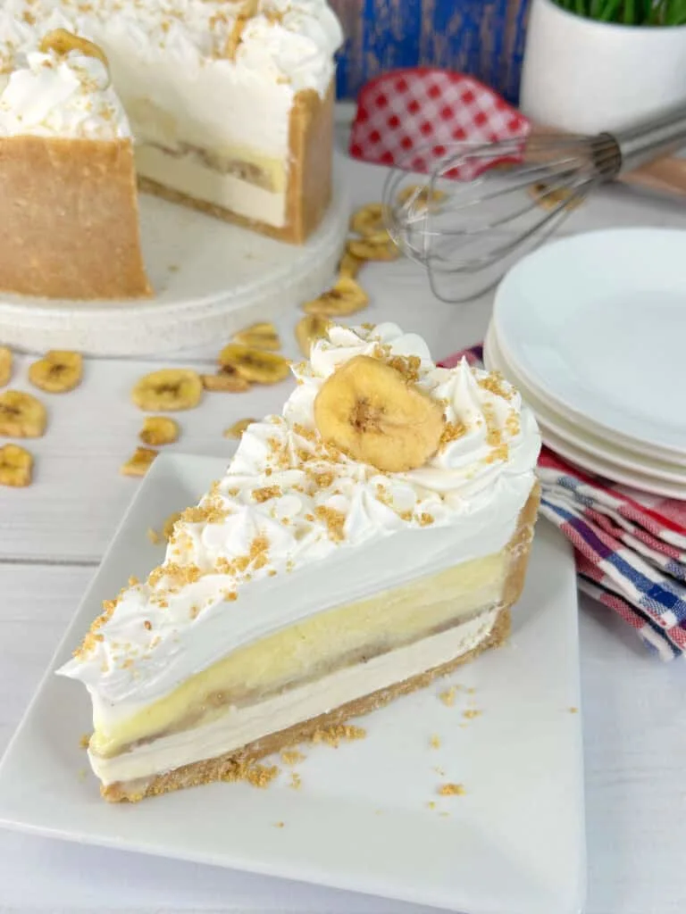 A slice of banana pudding cheesecake on a white plate.