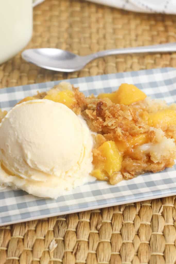 Peach crisp dump cake  with a scoop of vanilla ice cream.