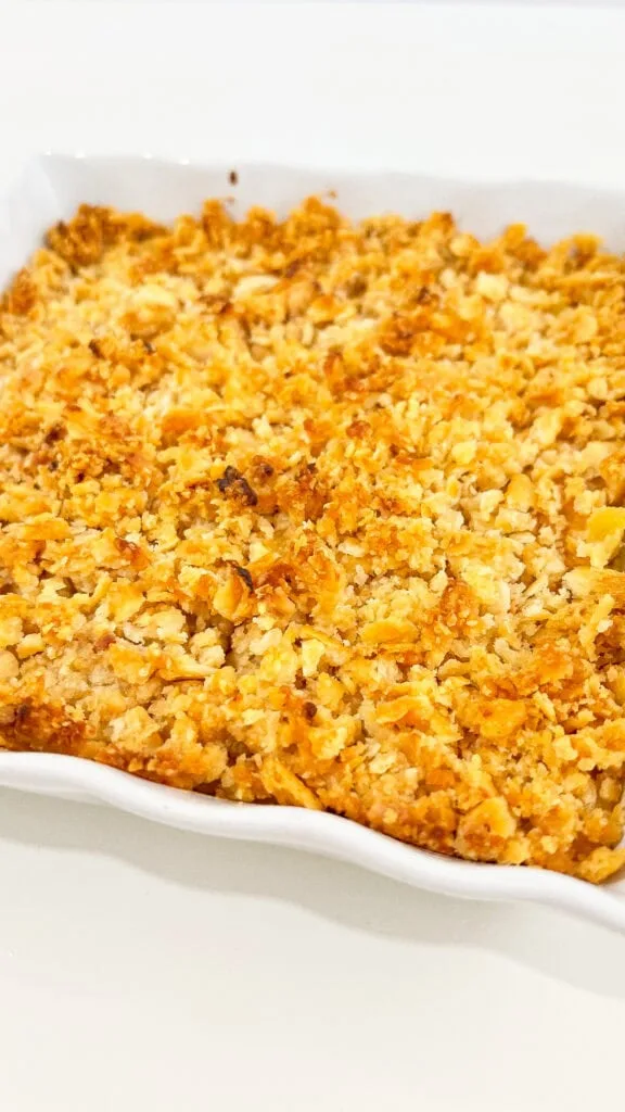 A pineapple casserole dish with cheese and crackers.