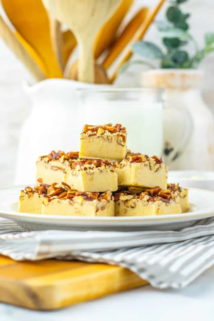 pecan pie fudge topped with chopped nuts on a white plate for dessert.