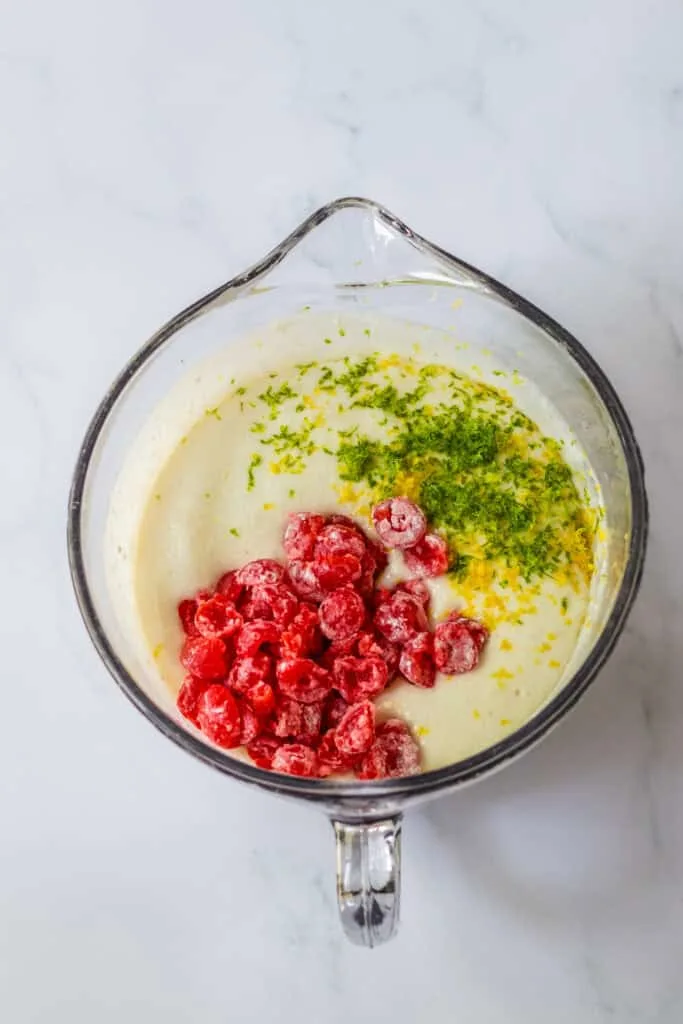 All ingredients, cake mix, sprite, cherries with lemon zest in a glass bowl mixed to make cake batter.