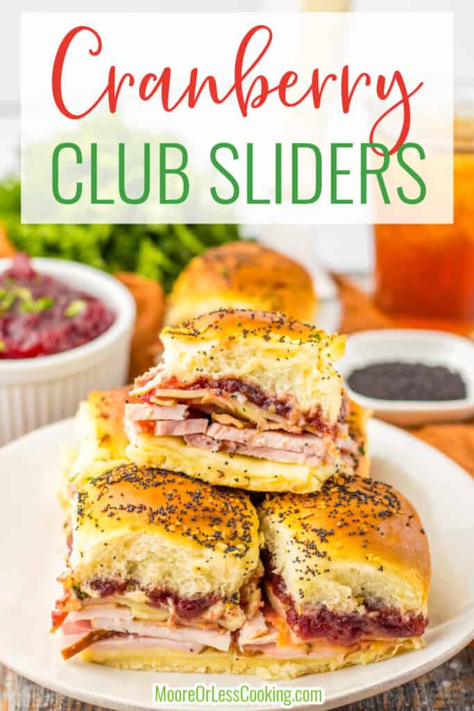 Cranberry club sliders on a white plate with side dishes and drinks in the background.