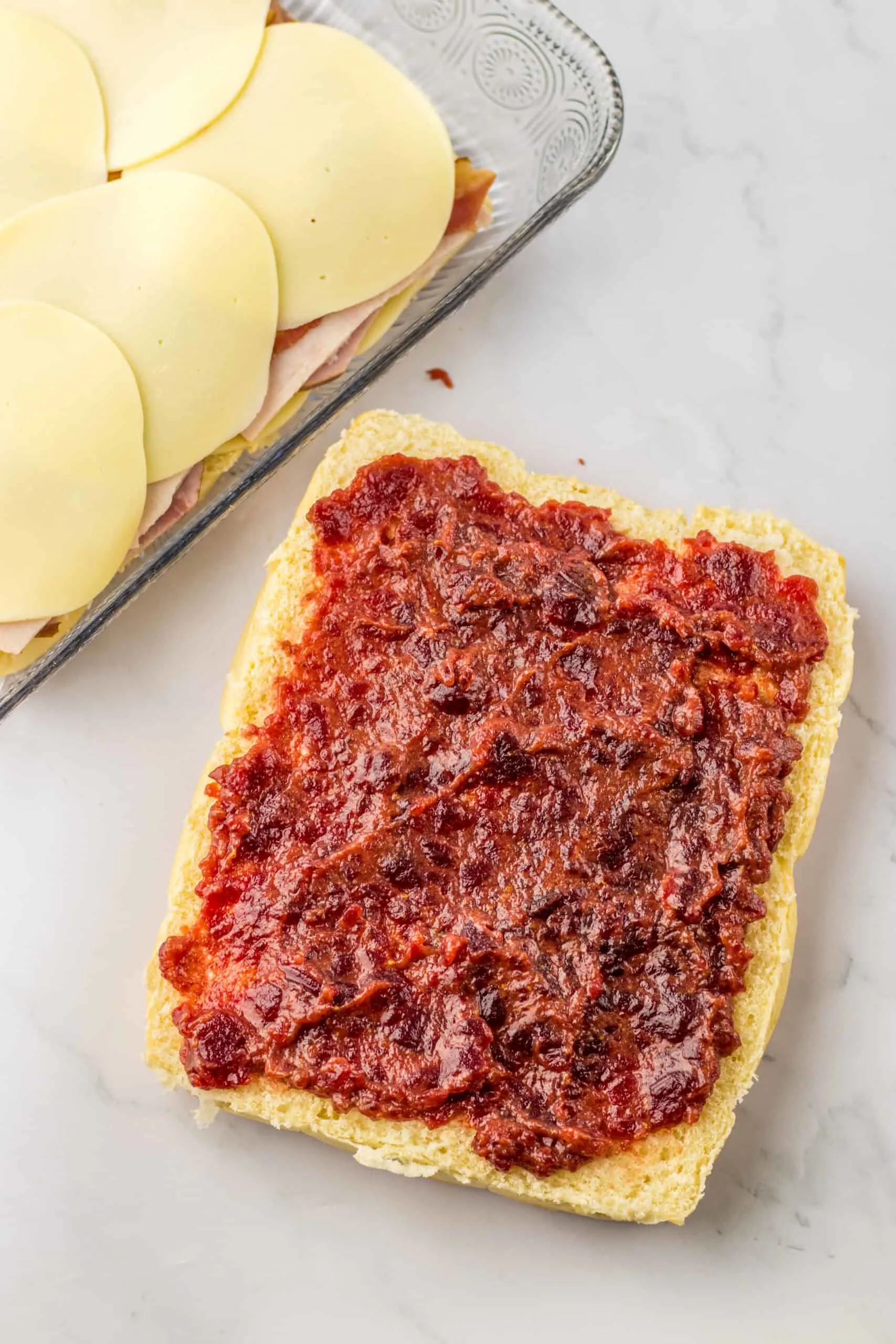Buttered bread with cranberry sauce spread on top, fresh ingredients for homemade sliders