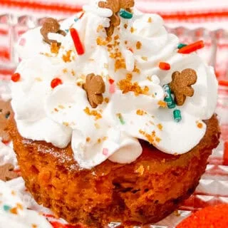 Gingerbread Cheesecake Bites cupcake with whipped cream, gingerbread men, sprinkles for holiday dessert.