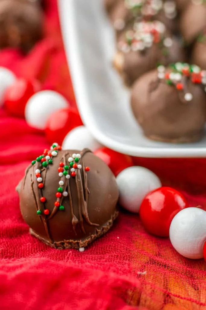 Chocolate truffle on cloth next to tray of truffles