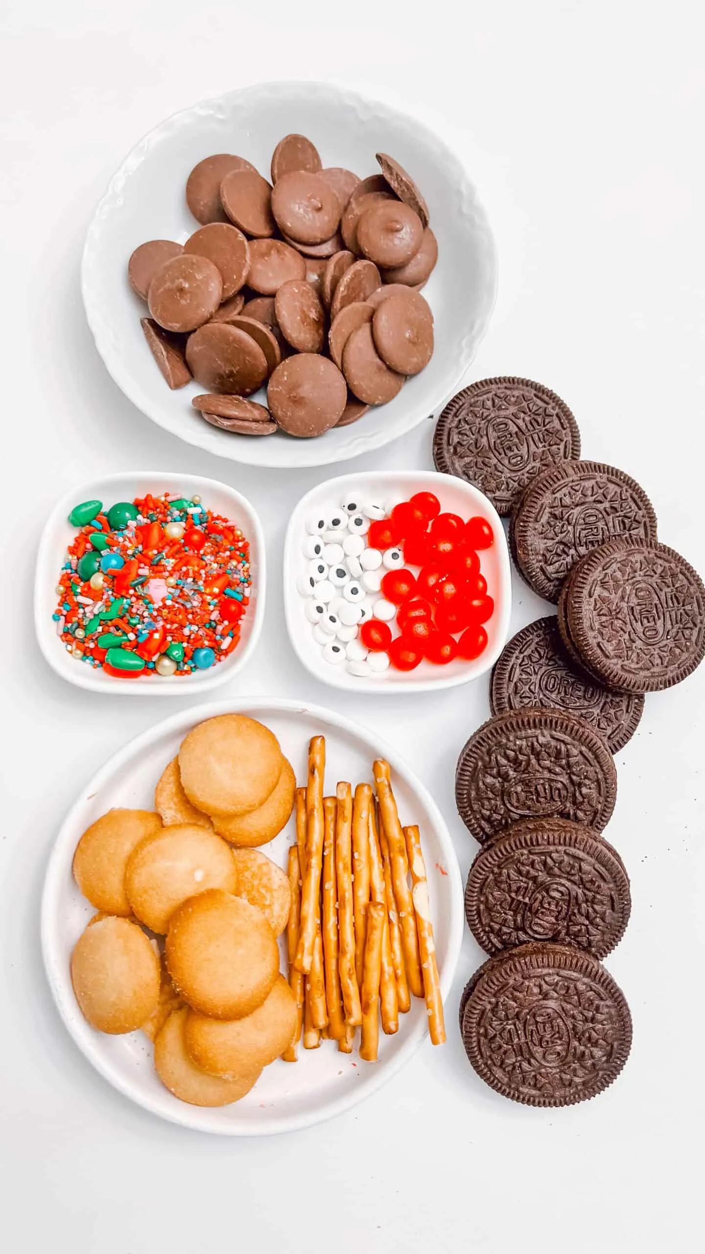 Brightly colored sprinkles, jelly beans, and mini candies with chocolate cookies and peanut butter cups.