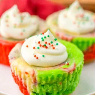 Festive cupcakes topped with white frosting, sprinkles, and colorful liners for Christmas celebrations.