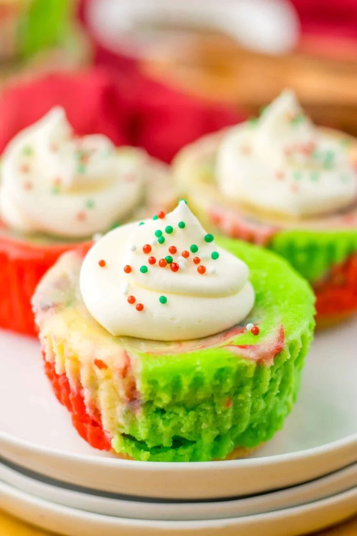Festive cupcakes topped with white frosting, sprinkles, and colorful liners for Christmas celebrations.