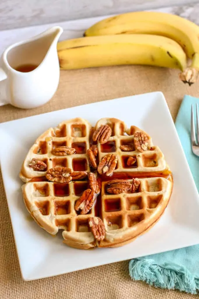 Delicious banana waffles topped with pecans, perfect for a cozy breakfast or brunch.