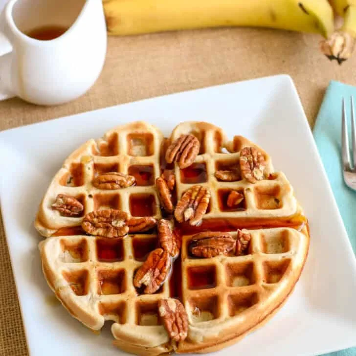 Delicious banana waffles topped with pecans, perfect for a cozy breakfast or brunch.