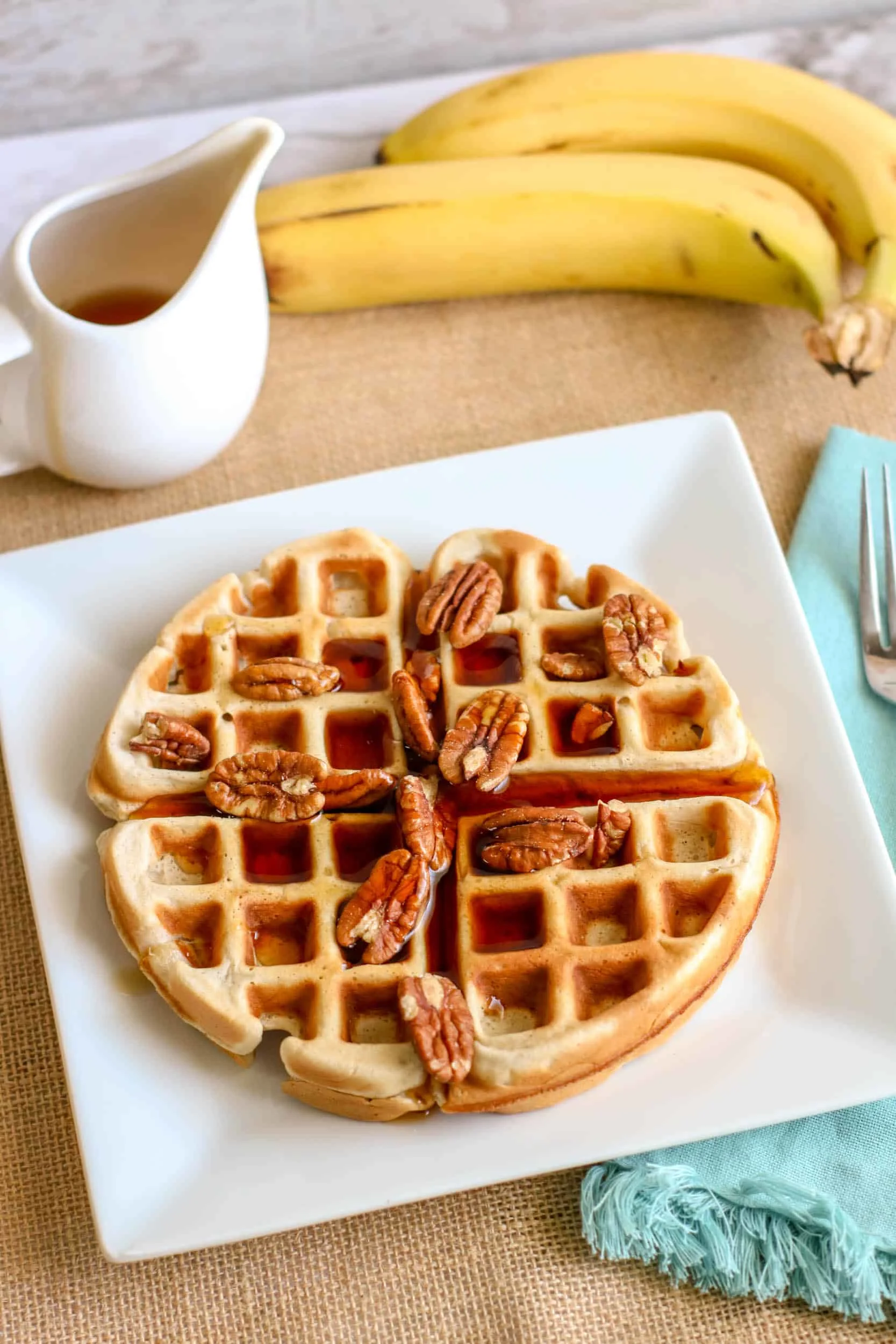 Delicious banana waffles topped with pecans, perfect for a cozy breakfast or brunch.